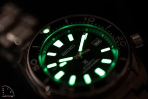 Fotografía en la penumbra del lumen verde de un reloj seiko sumo de alta relojería.