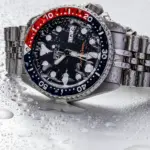 Reloj Seiko SKX009 con bisel Pepsi sobre superficie mojada