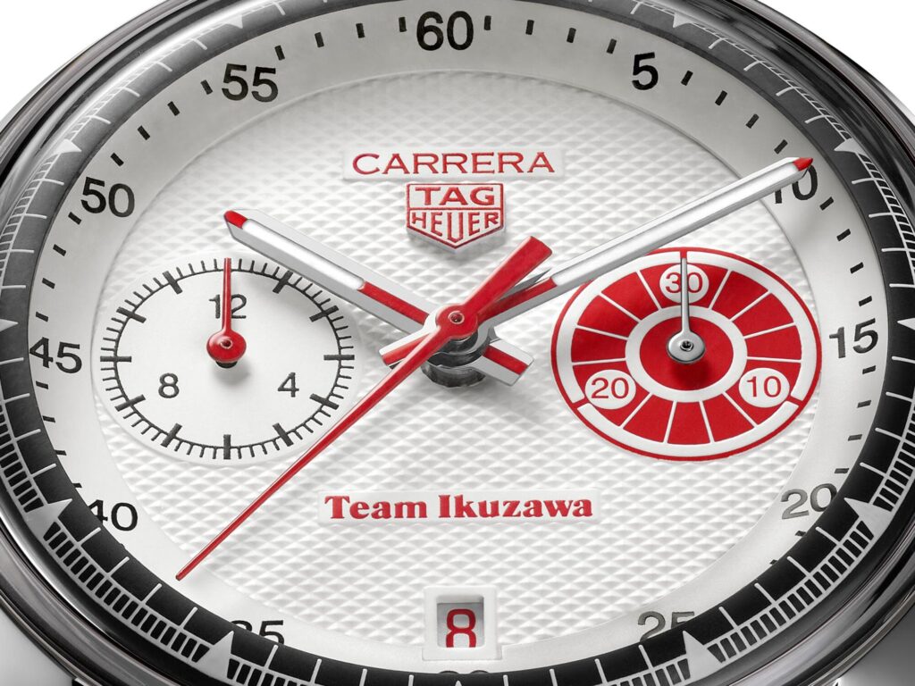Primer plano de los contadores rojos y la firma Team Ikuzawa a las 6 en la esfera