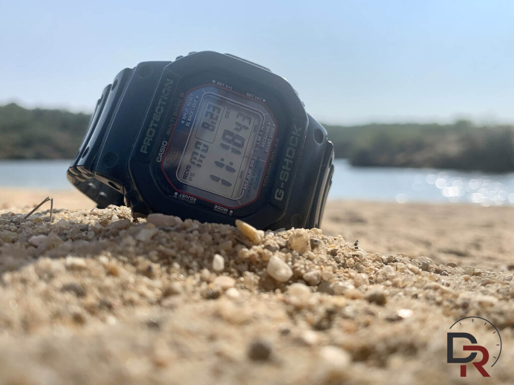 Reloj Casio G-Shock en la arena de la playa para el artículo de relojes en verano