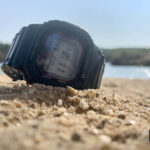 Reloj Casio G-Shock en la arena de la playa para el artículo de relojes en verano