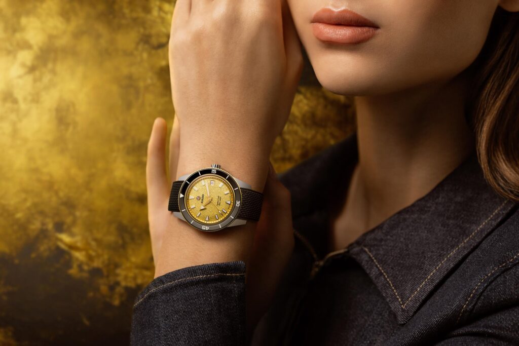 Reloj Rado Captain Cook de 39 mm con esfera dorada con efecto polvo de diamante y correa de caucho.