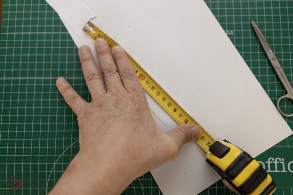 Truco para medir la muñeca utilizando una tira de papel y una regla para saber la medida de la correa de reloj.