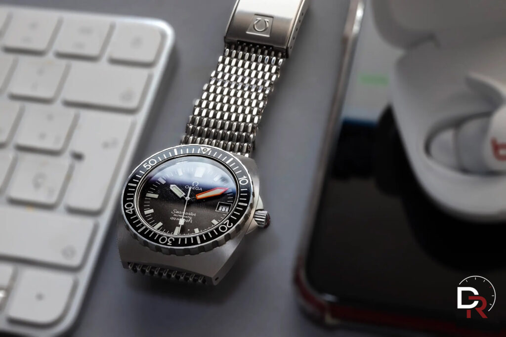 Bodegón de reloj Omega sobre escritorio