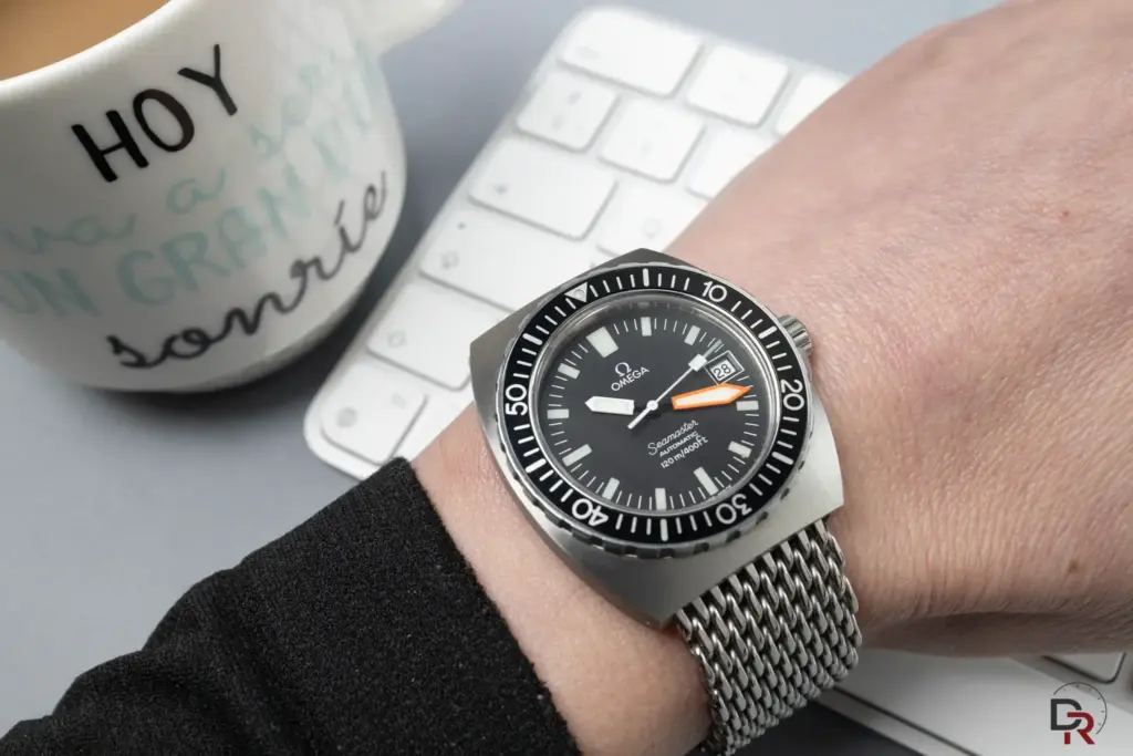 Omega Seamaster en la muñeca sobre escritorio