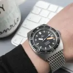 Fotografía de muñeca de un reloj vintage Omega Seamaster sobre un escritorio de trabajo con iluminación natural suave