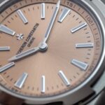 Macrofotografía del dial cepillado en tono salmón de un Vacheron Constantin Overseas, mostrando el control de luz y reflejos en cristal de zafiro.