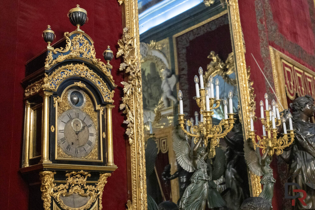 Longcase regulator clock by John Ellicott (c. 1745) in ebony case with gilt-bronze mounts against red velvet walls