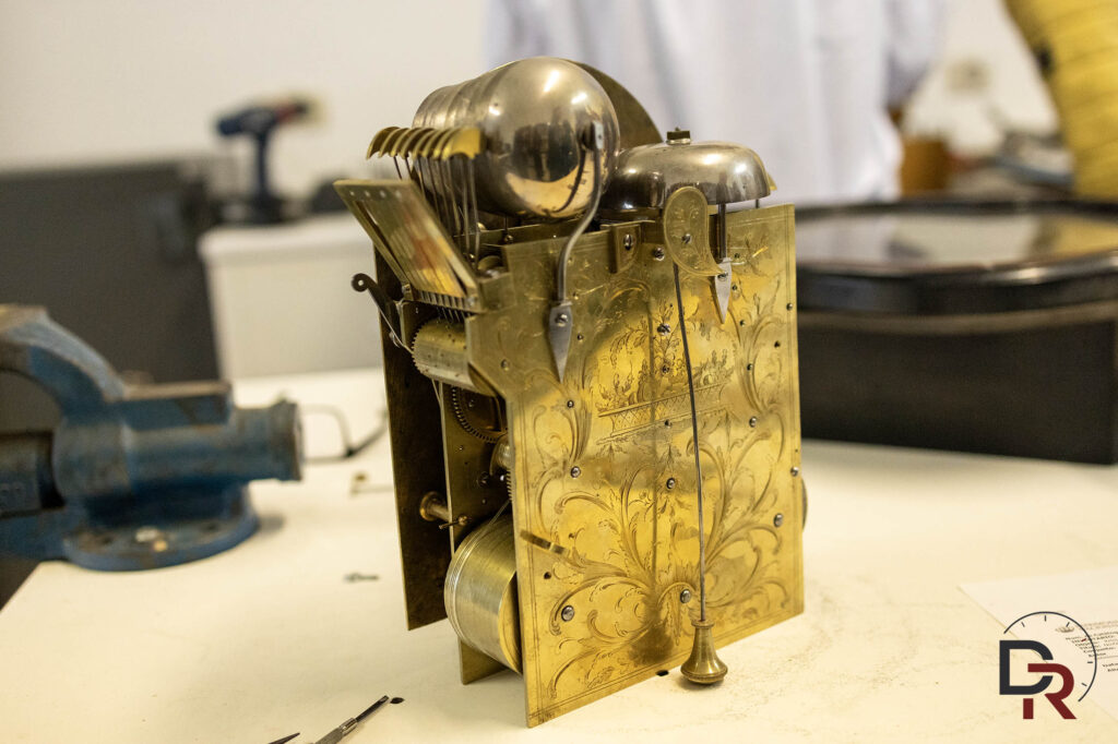 Antique clock movement featuring a multi-bell chiming mechanism in the workshop