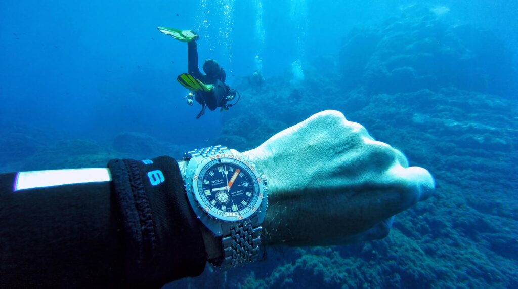 Reloj DOXA SUB 300T Sharksaver Fins Attached bajo el agua durante una sesión de buceo.