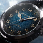 Reloj Hamilton Khaki Field Murph de 38 mm con esfera azul cósmica y correa de piel sobre fondo de estudio