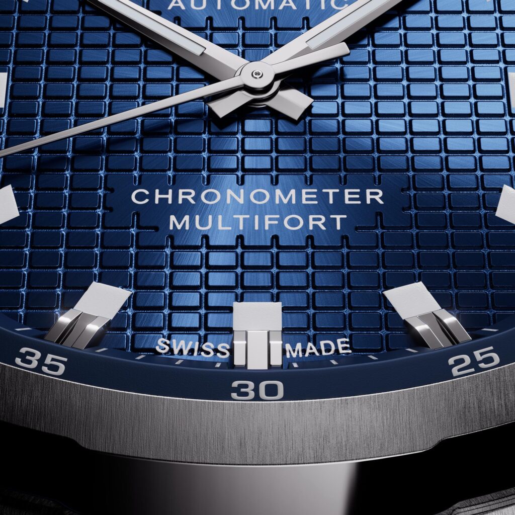Macro detail of the blue checkerboard dial and big date aperture at 12 o'clock